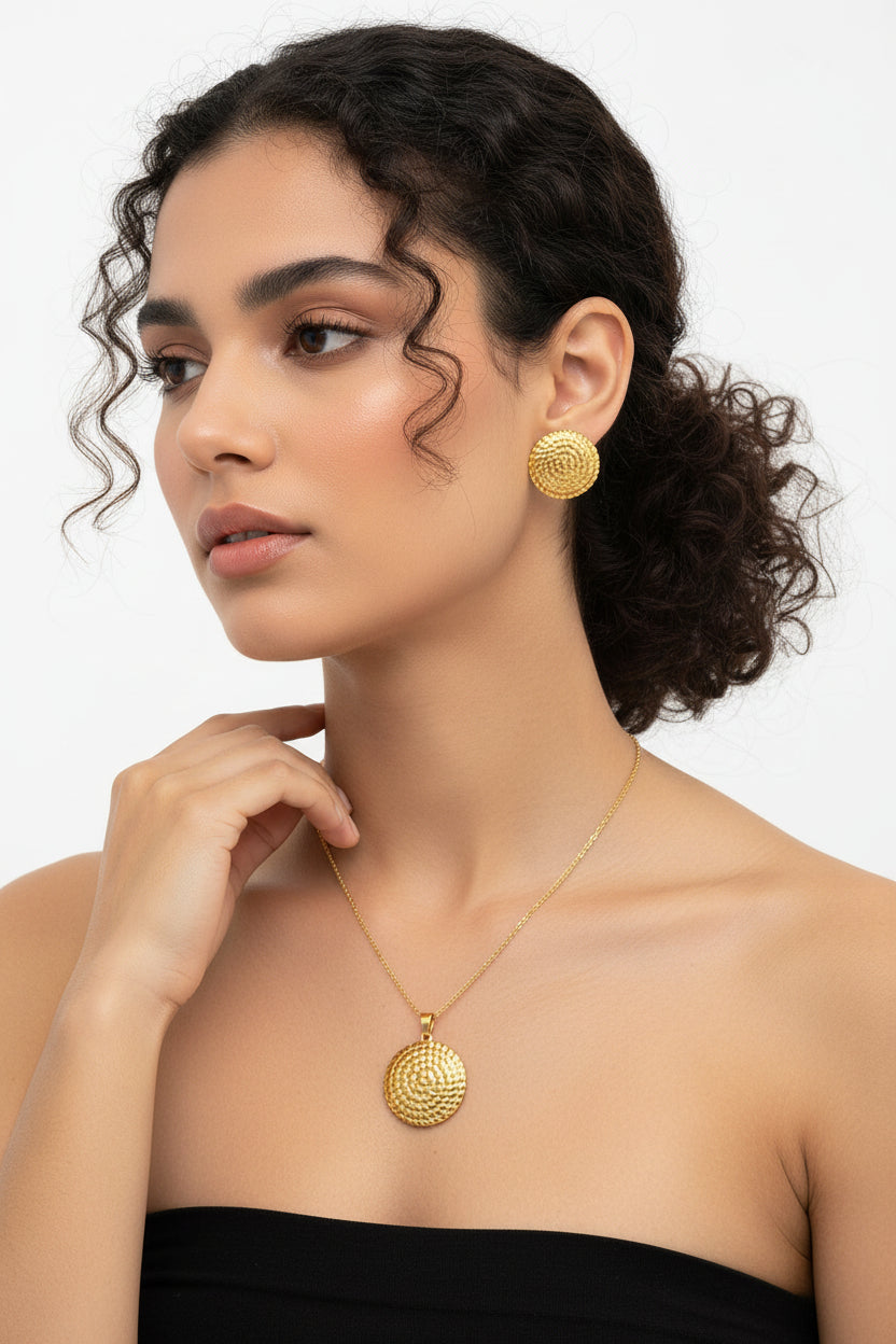 Ensemble bijoux en acier inoxydable plaqué or avec médaillon spiralé, comprenant un collier et une paire de boucles d'oreilles assortis.